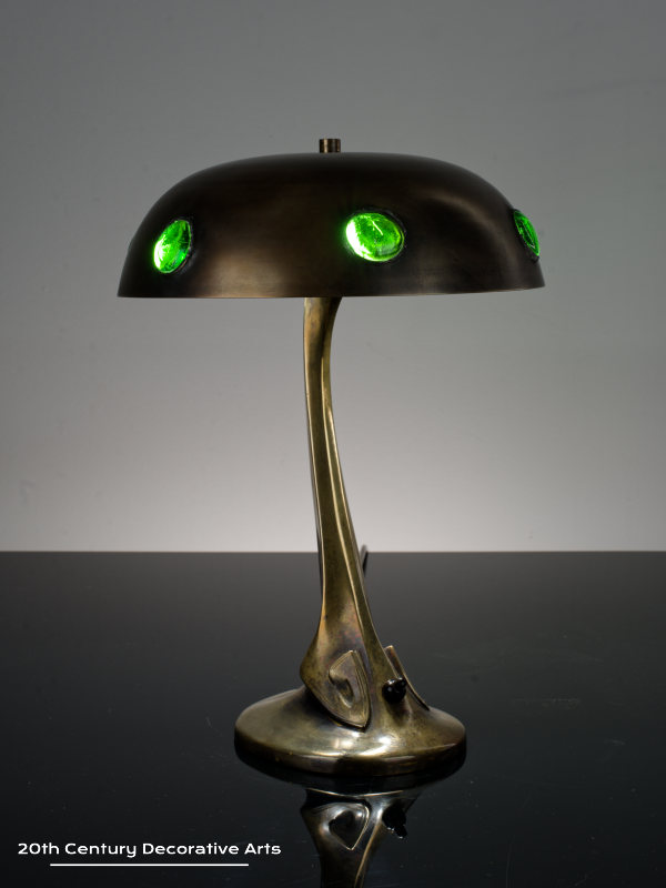 A bronze jugendstil / secessionist bronze table lamp, Austria circa 1900, the stylised bronze base supporting a dome shade inset with green glass cabochons