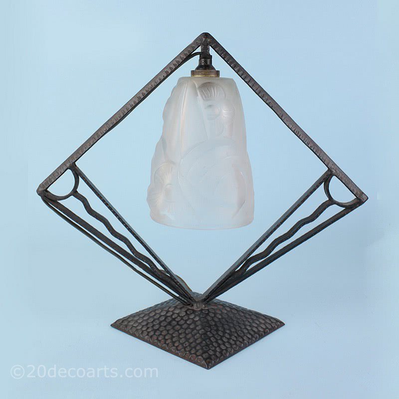  20th Century Decorative Arts |A wrought iron art deco lamp with shade by Degue, circa late 1920's, the stylised frame supporting the frosted shade