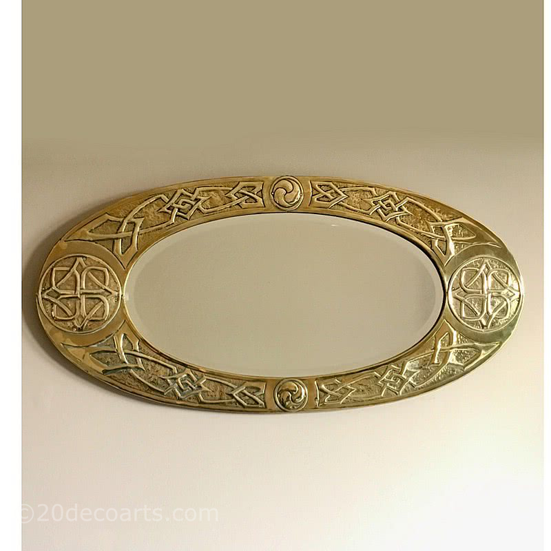  20th Century Decorative Arts |An Arts and Crafts brass oval mirror with Celtic, entrelac repoussé decoration in the Glasgow Style, circa 1900