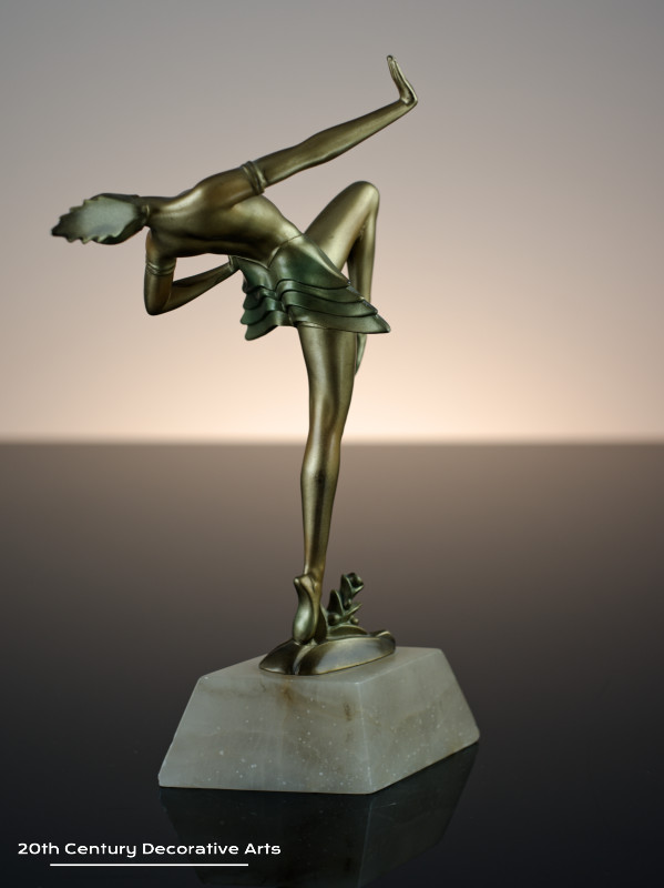   Art Deco German spelter figure circa 1930, the female dancer in futuristic ballet costume, cold-painted gold and enamelled, mounted on a shaped alabaster base