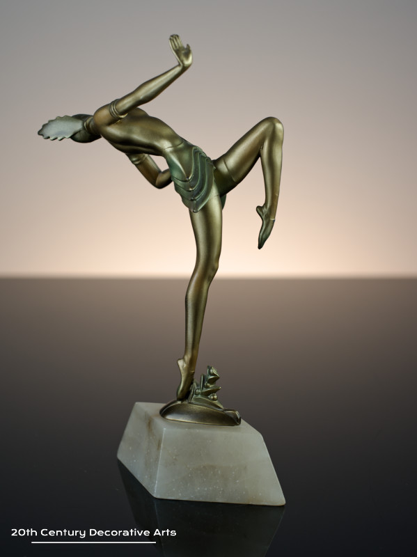   Art Deco German spelter figure circa 1930, the female dancer in futuristic ballet costume, cold-painted gold and enamelled, mounted on a shaped alabaster base