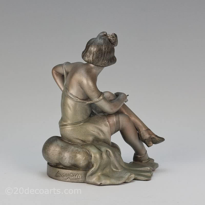  20th Century Decorative Arts |An Art Deco spelter figure by A. Lesueur France c1920s, the silvered and enamel painted young woman sat on a cushion smoking a cigarette