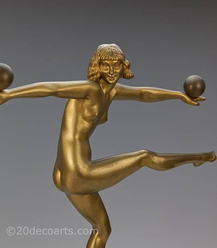  20th Century Decorative Arts |A stunning Art Deco French bronze figure by Marcel-Andre Bouraine, circa 1925, " Jongleuse". depicting a stylish dancer, with a gold painted finish, mounted on a black and brown marble plinth