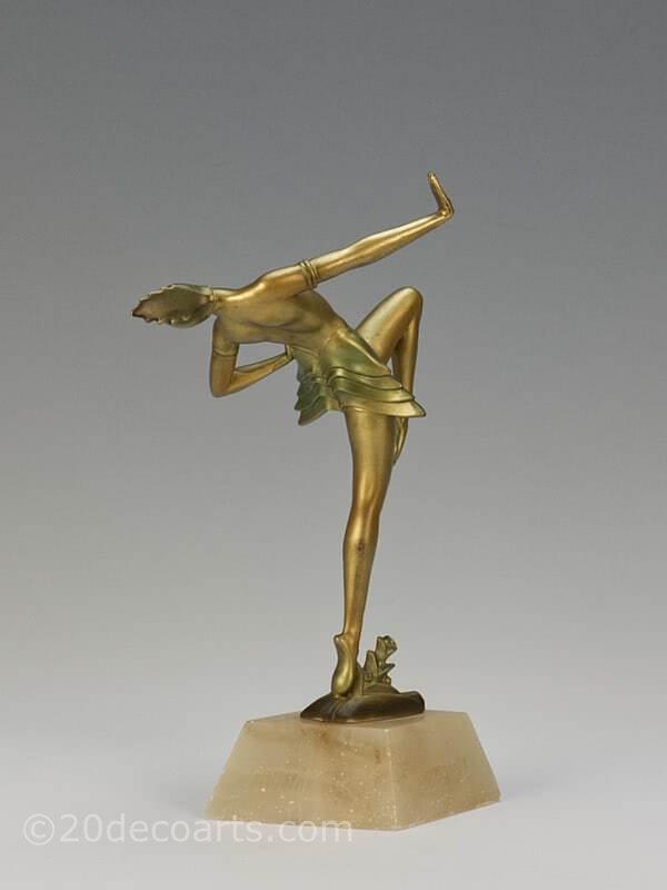  20th Century Decorative Arts |A very stylish Art Deco German spelter figure circa 1930, the female dancer in futuristic ballet costume, cold-painted gold and enamelled, mounted on a shaped alabaster base